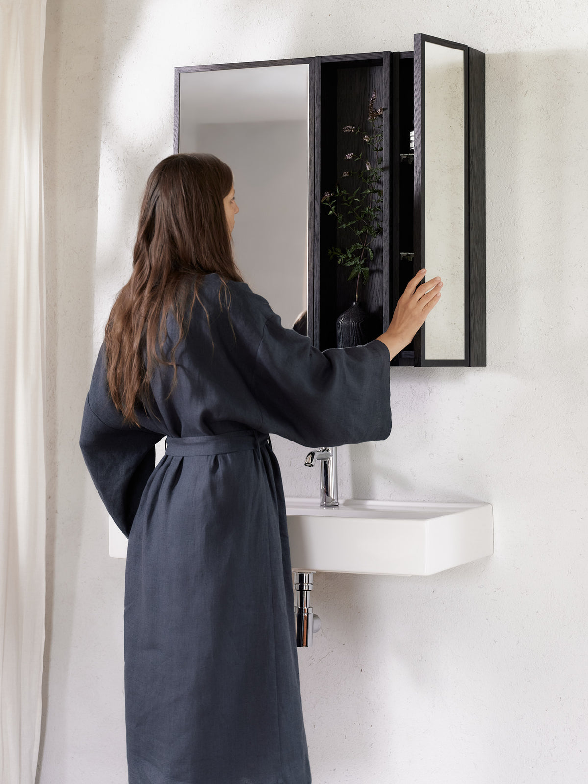 Black oak modular mirror cabinet in a bathroom with mirrored doors open