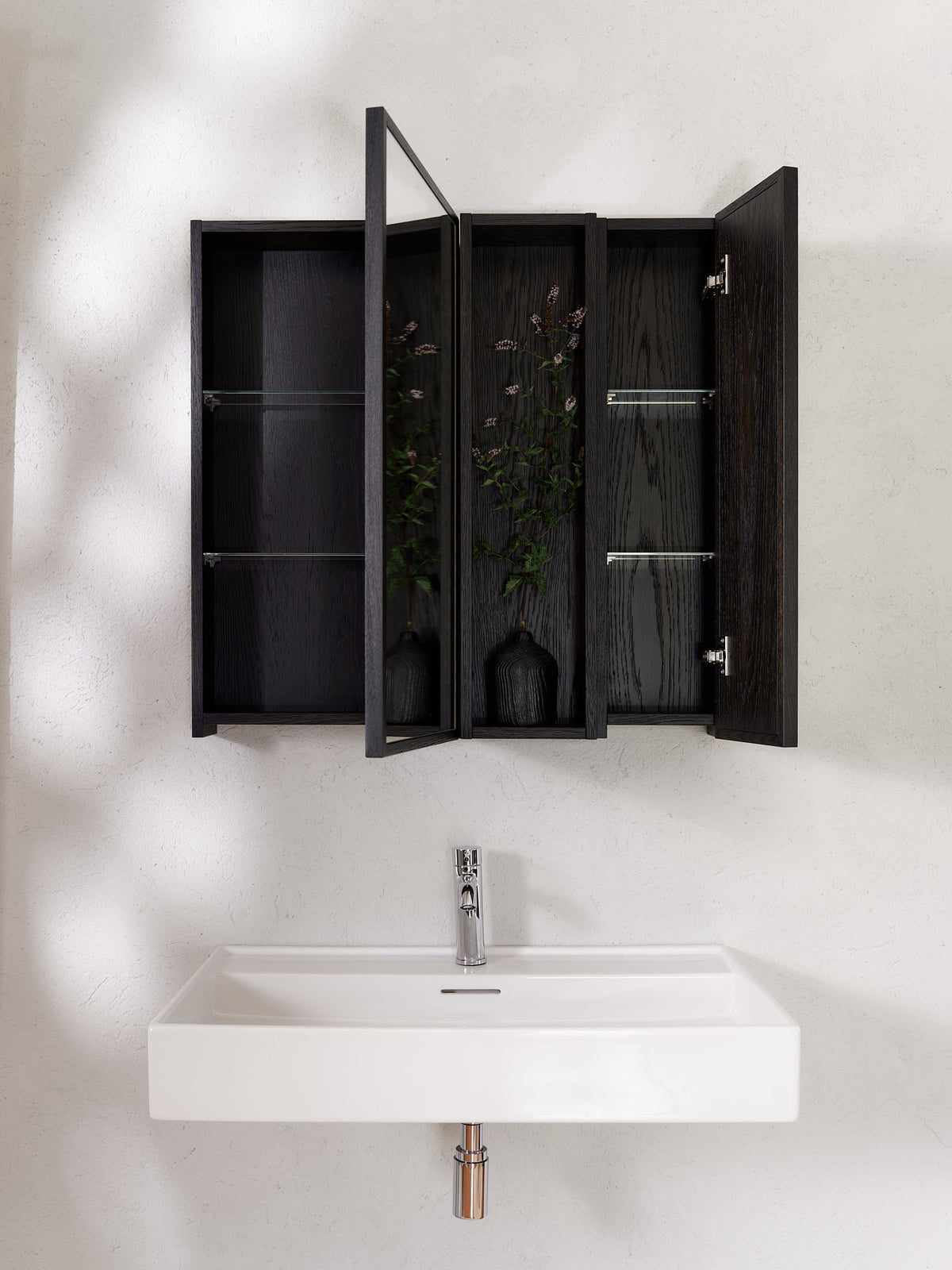 Black oak modular bathroom cabinet system with open mirrored doors and glass shelves