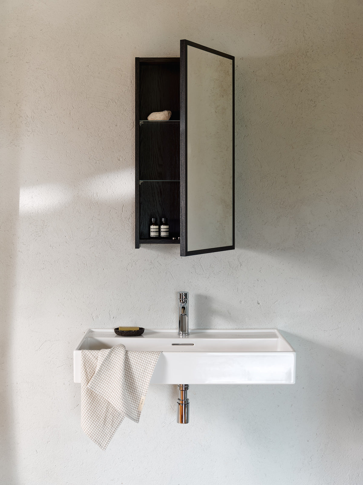 Black oak wall-mounted bathroom mirror cabinet open above a sink